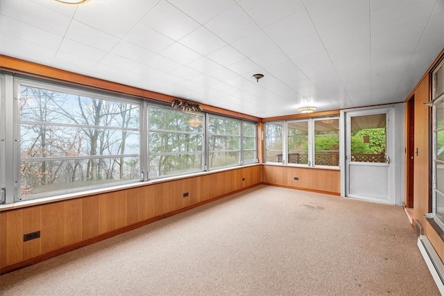 unfurnished sunroom with plenty of natural light and a baseboard heating unit