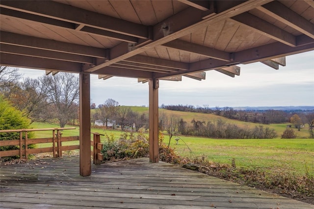 wooden terrace featuring a rural view and a lawn