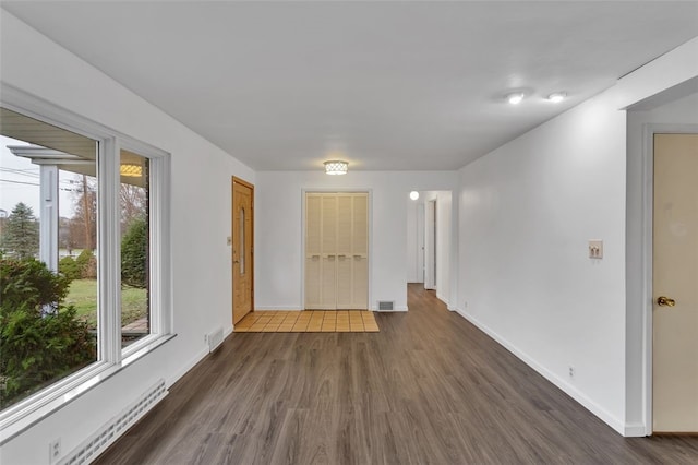 empty room featuring dark hardwood / wood-style flooring and baseboard heating