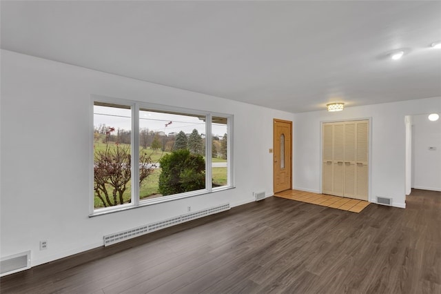 unfurnished living room with baseboard heating and dark wood-type flooring