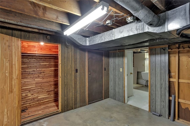 basement featuring wooden walls