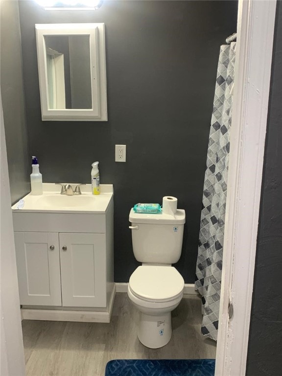 bathroom featuring vanity, wood-type flooring, and toilet