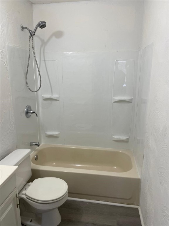 full bathroom with bathing tub / shower combination, toilet, vanity, and hardwood / wood-style flooring