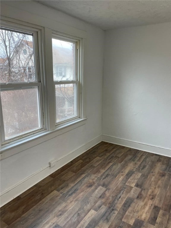 unfurnished room with dark hardwood / wood-style floors and a textured ceiling