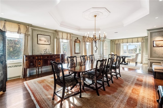 dining room featuring wood-type flooring, a wealth of natural light, and a tray ceiling