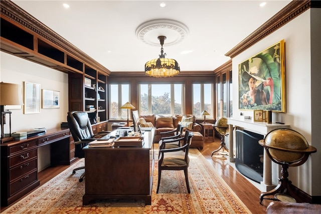 office space with light hardwood / wood-style flooring, ornamental molding, and a notable chandelier