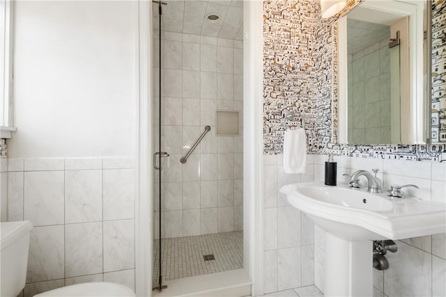 bathroom with toilet, tile walls, and walk in shower