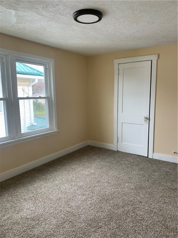 spare room with carpet flooring and a textured ceiling