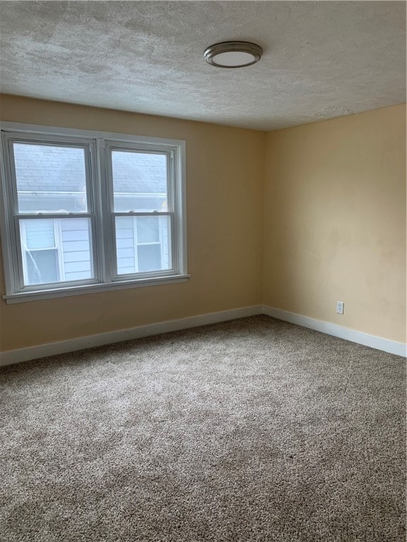 unfurnished room featuring carpet flooring and a textured ceiling