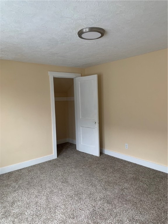 carpeted spare room featuring a textured ceiling