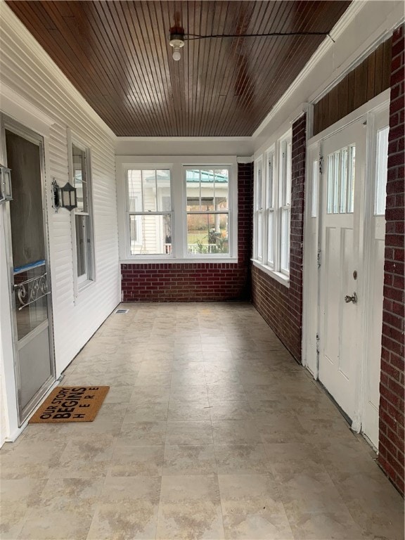 unfurnished sunroom with wood ceiling