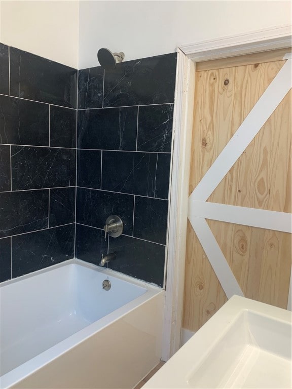 bathroom with sink and tiled shower / bath