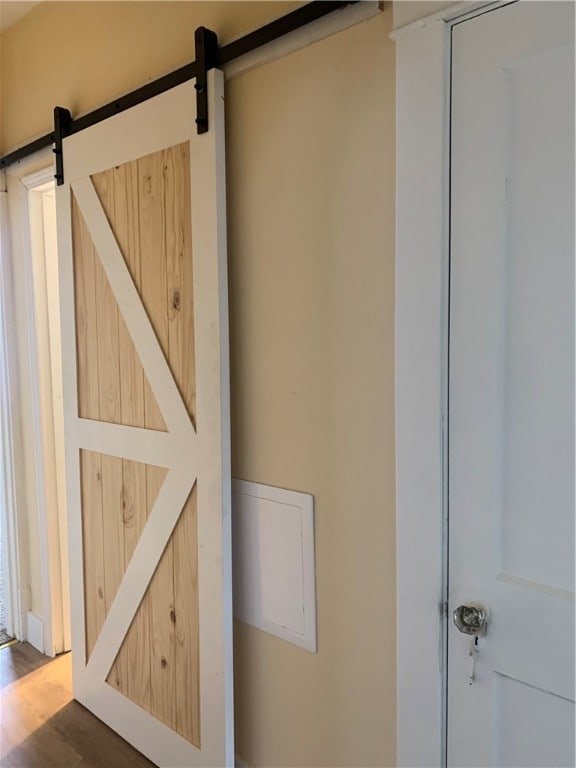 room details featuring a barn door and wood-type flooring