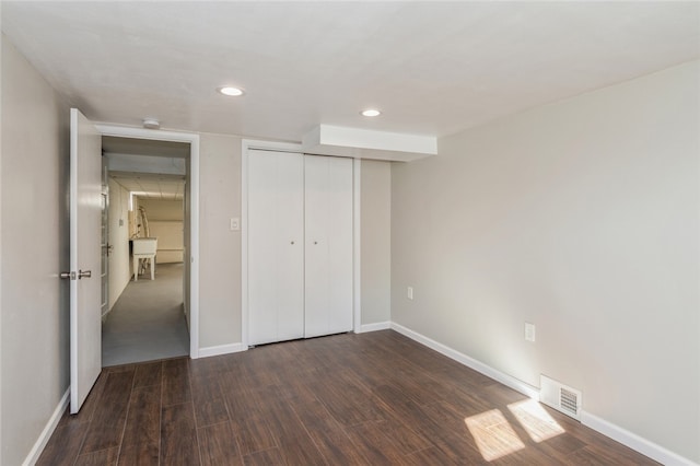 unfurnished bedroom featuring dark hardwood / wood-style flooring and a closet