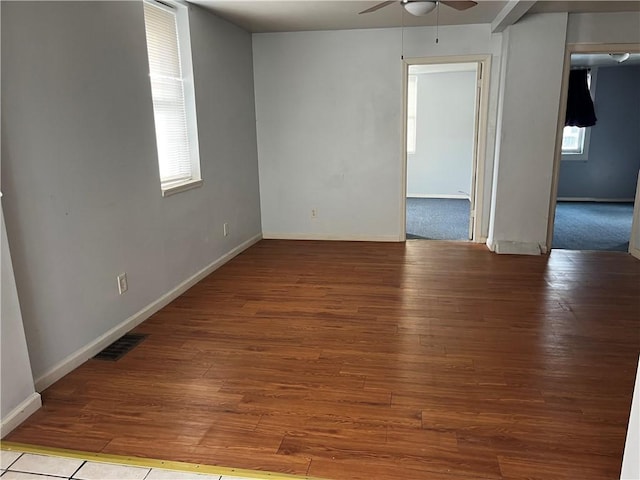 spare room featuring ceiling fan, baseboards, visible vents, and light wood-style floors