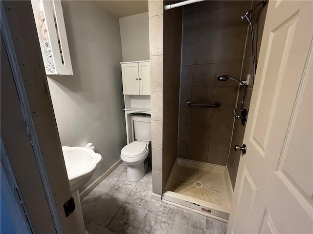 full bath with a stall shower, toilet, and baseboards