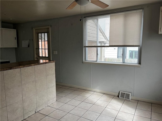 interior space featuring visible vents, ceiling fan, and light tile patterned floors