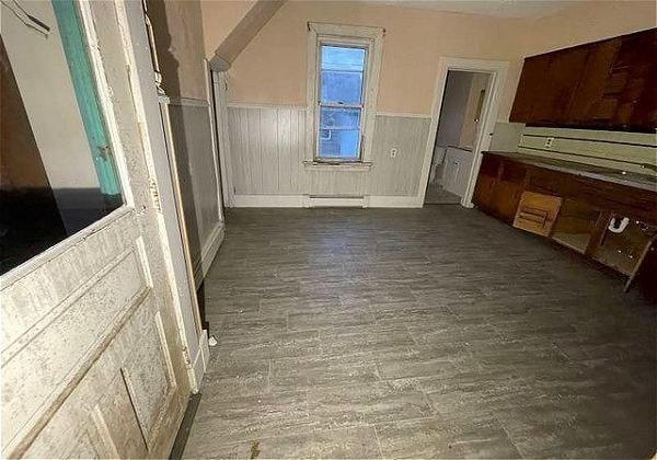 kitchen with dark hardwood / wood-style floors and a baseboard heating unit