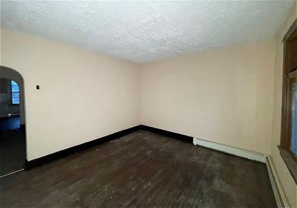 empty room featuring dark hardwood / wood-style flooring and a textured ceiling