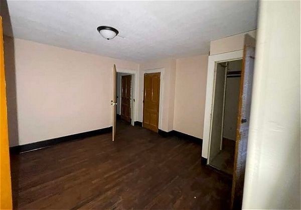 unfurnished room with dark hardwood / wood-style flooring