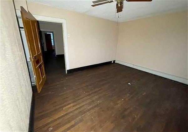 spare room featuring dark hardwood / wood-style floors and ceiling fan