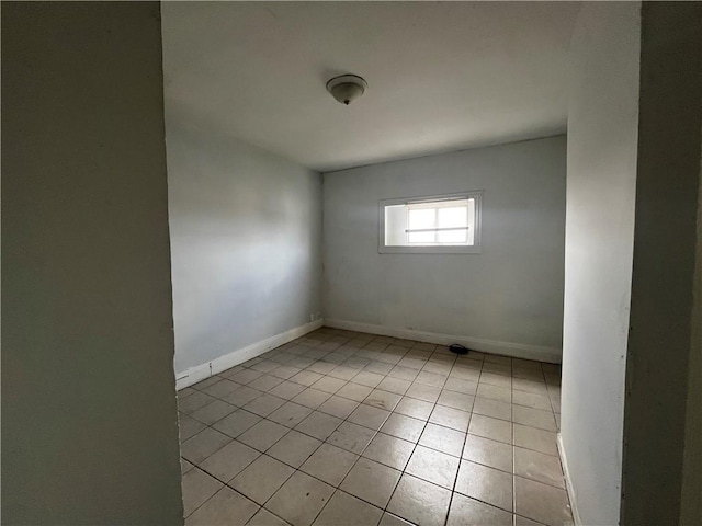spare room featuring baseboards and light tile patterned floors