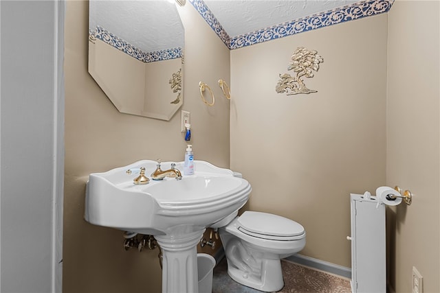 bathroom with a textured ceiling and toilet