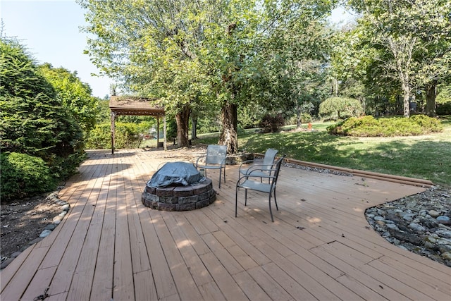 wooden terrace with a yard and an outdoor fire pit