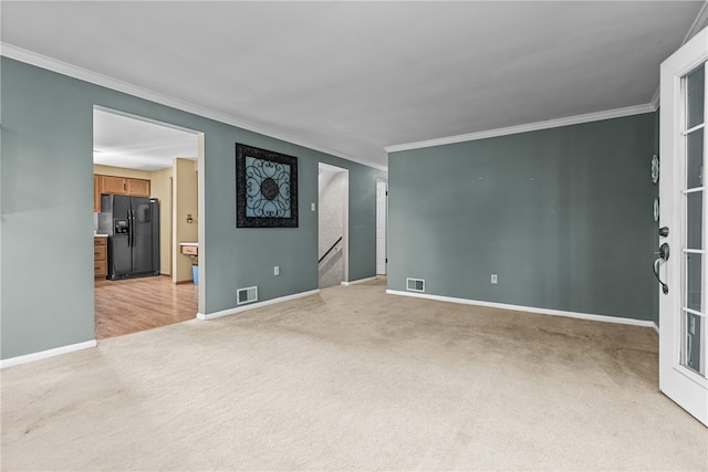 unfurnished room with ornamental molding and light carpet