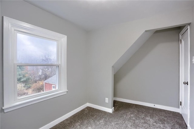 additional living space with dark colored carpet