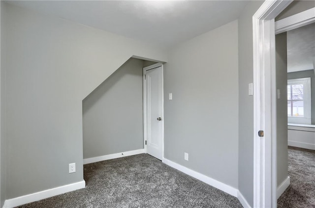 additional living space with dark colored carpet