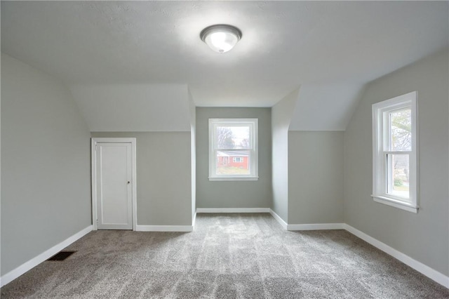 bonus room featuring light colored carpet and lofted ceiling