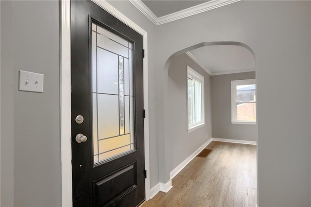 foyer entrance with light hardwood / wood-style floors and crown molding