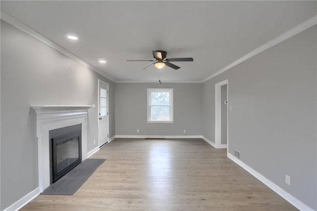 unfurnished living room featuring light hardwood / wood-style flooring, ceiling fan, and ornamental molding