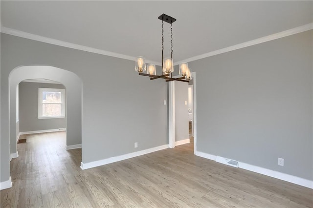 unfurnished room featuring an inviting chandelier, ornamental molding, and light hardwood / wood-style flooring