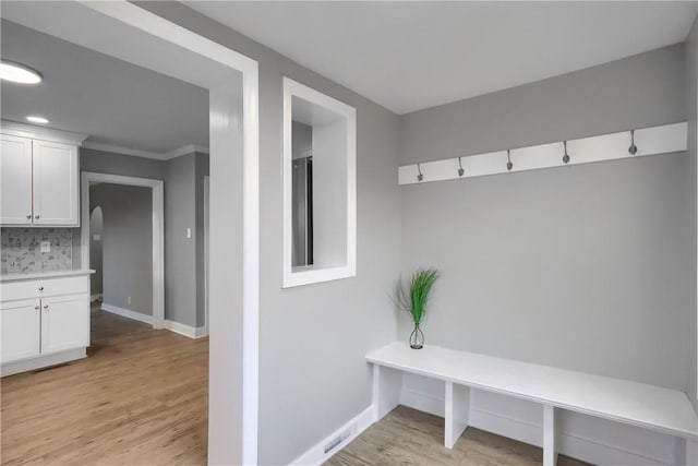 mudroom with light wood-type flooring and crown molding