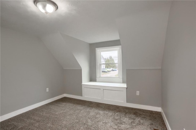 additional living space featuring carpet floors and vaulted ceiling