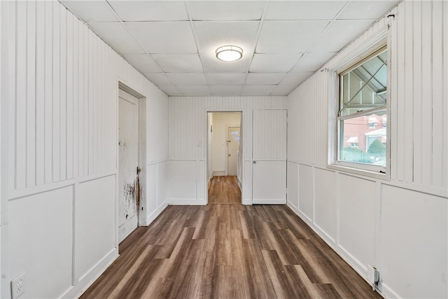 unfurnished room featuring dark hardwood / wood-style flooring and a paneled ceiling