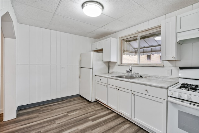 kitchen featuring sink, white cabinets, hardwood / wood-style floors, and white appliances