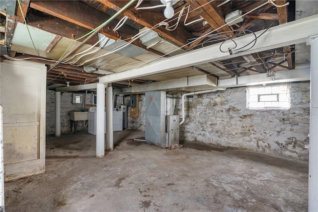 basement featuring sink, washer / clothes dryer, and heating unit