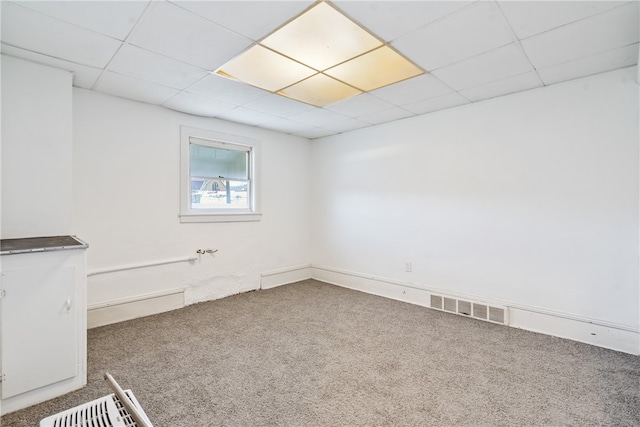 carpeted spare room with a drop ceiling