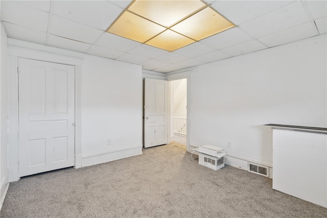 carpeted spare room featuring a paneled ceiling