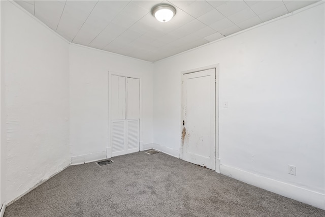 carpeted spare room featuring crown molding