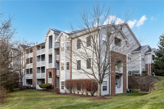 exterior space featuring a lawn and central AC unit