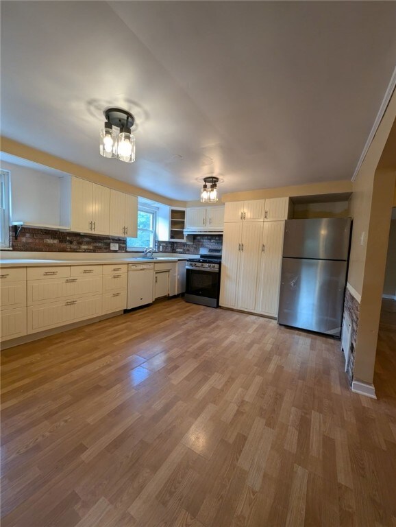 2225 Swallow Hill Rd, Scott Twp Sal, PA 15220 - kitchen featuring stainless steel appliances, decorative backsplash, wood finished floors, and a sink