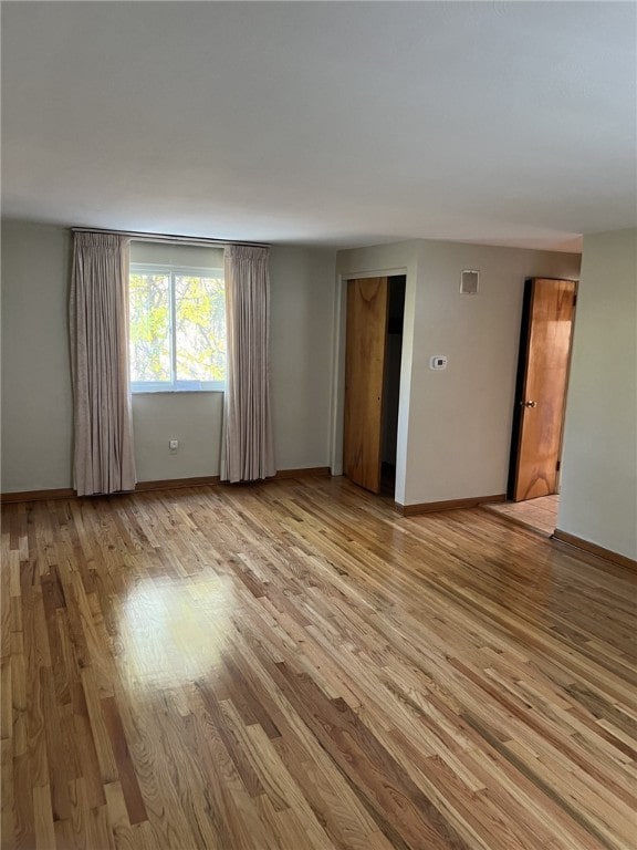 spare room with light wood-style flooring and baseboards