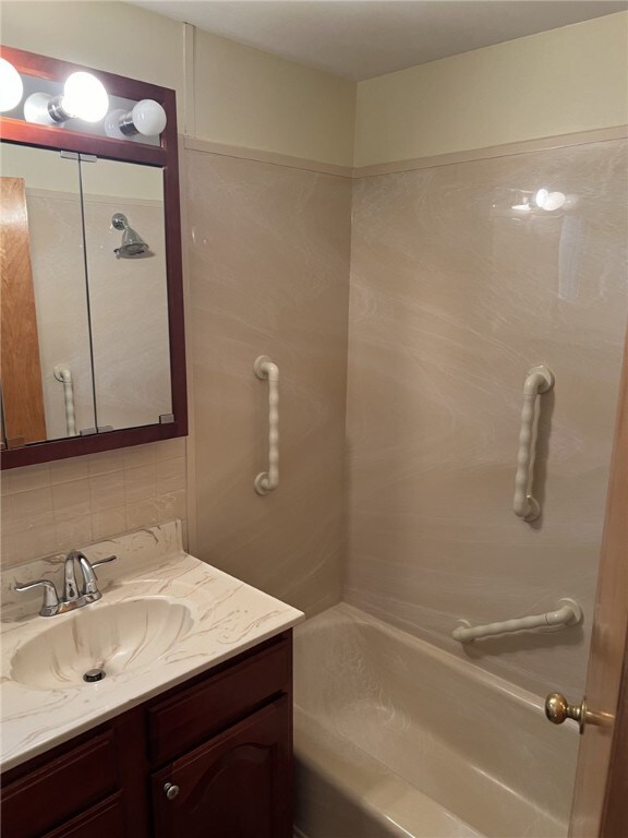 full bath featuring tasteful backsplash, shower / bathtub combination, and vanity