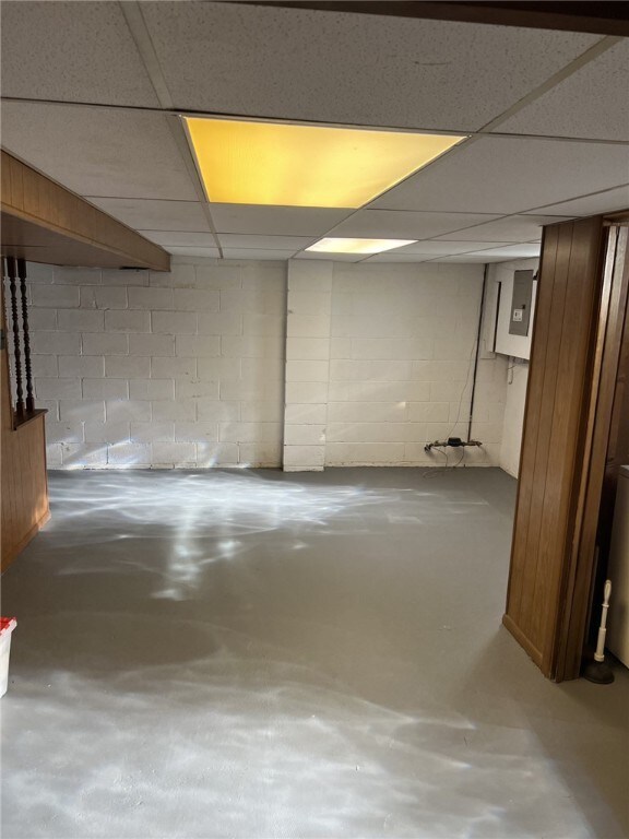finished below grade area featuring concrete block wall and electric panel