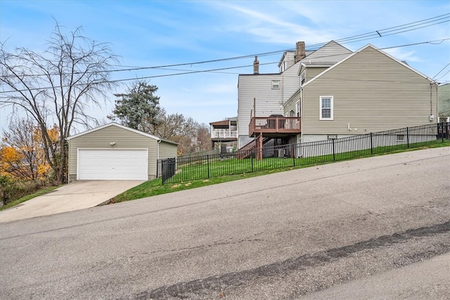 view of side of home with a yard, an outbuilding, a deck, and a garage