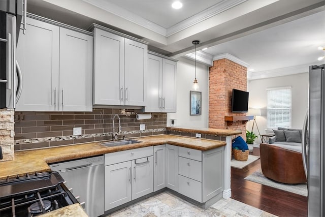 kitchen featuring crown molding, sink, hanging light fixtures, light hardwood / wood-style flooring, and appliances with stainless steel finishes